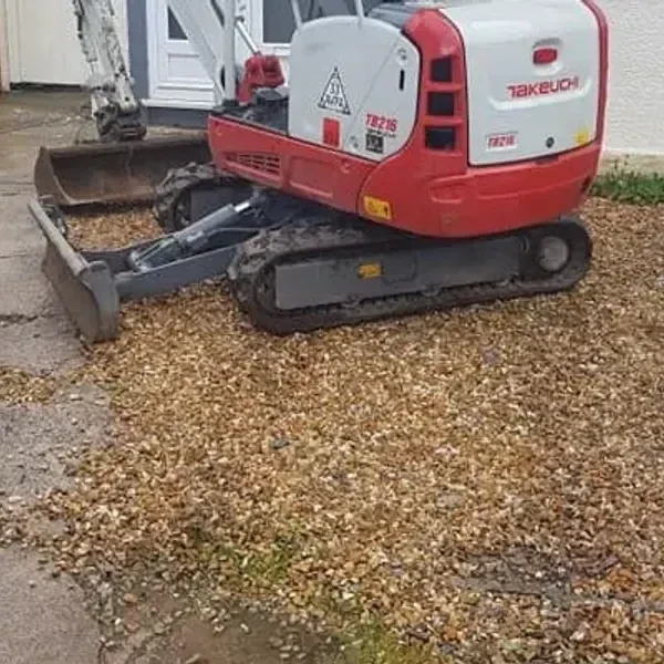 Mini digger clearing gravel
