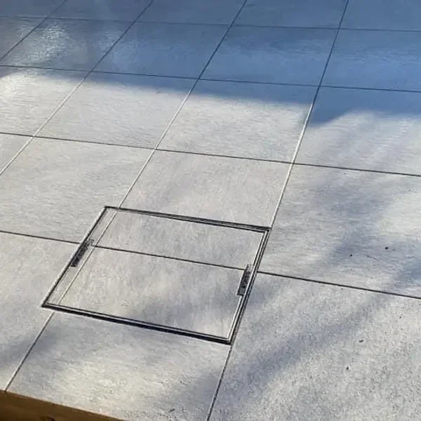 Pale slab patio with an inspection cover