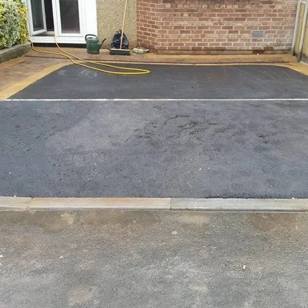 Tarmac driveway framed by block edging