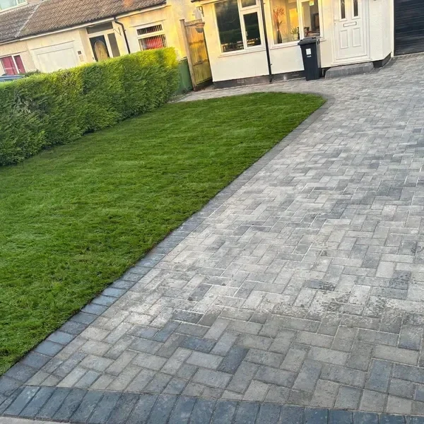 Grey block paving driveway beside a lawn