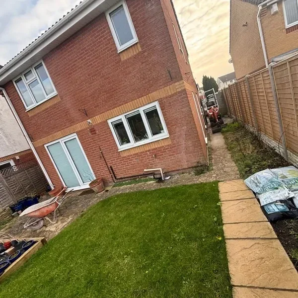 Slab patio and lawn behind a brick house