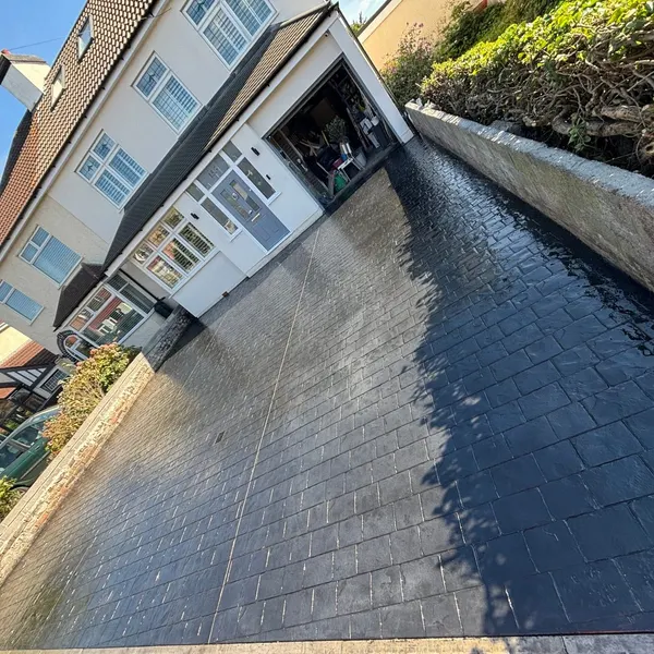 Dark grey block paving driveway after rain