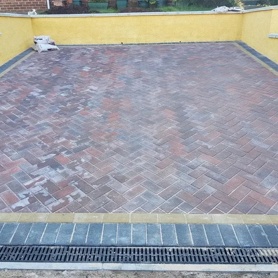 Channel drain across the front of a block paved driveway