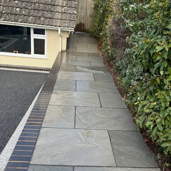 Grey slab path beside a hedge