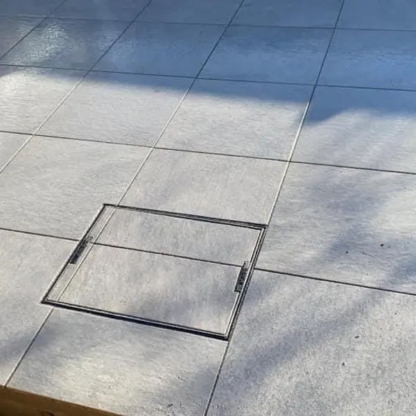 Pale slab patio with an inspection cover