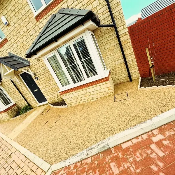 Golden resin bound driveway with a red block border