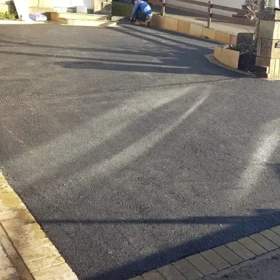 Black tarmac driveway being finished