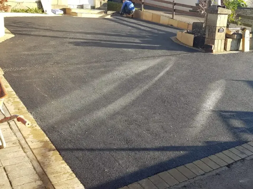 Black tarmac driveway with a block edge